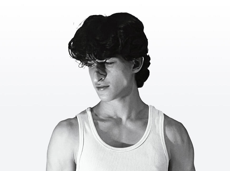 Artist - alp_draw Black and white artistic portrait of André Santos (alp_draw) looking down, wearing a white tank top. Represents the personal side of the anime illustrator and engineering student.